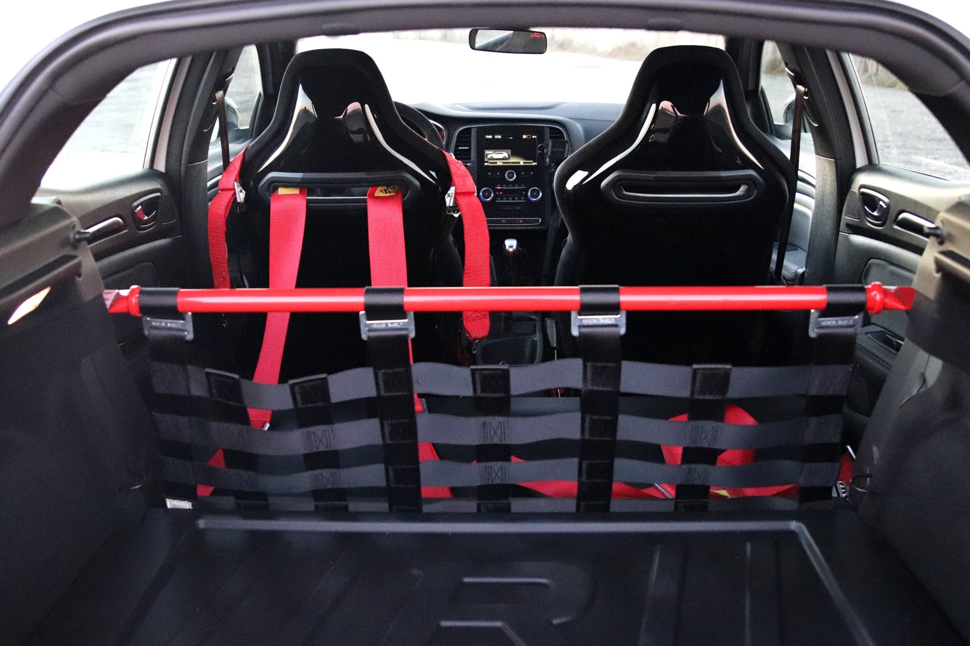 Intérieur allégé de la Mégane Trophy-R avec baquets Sabelt, harnais rouges et filet à la place de la banquette arrière