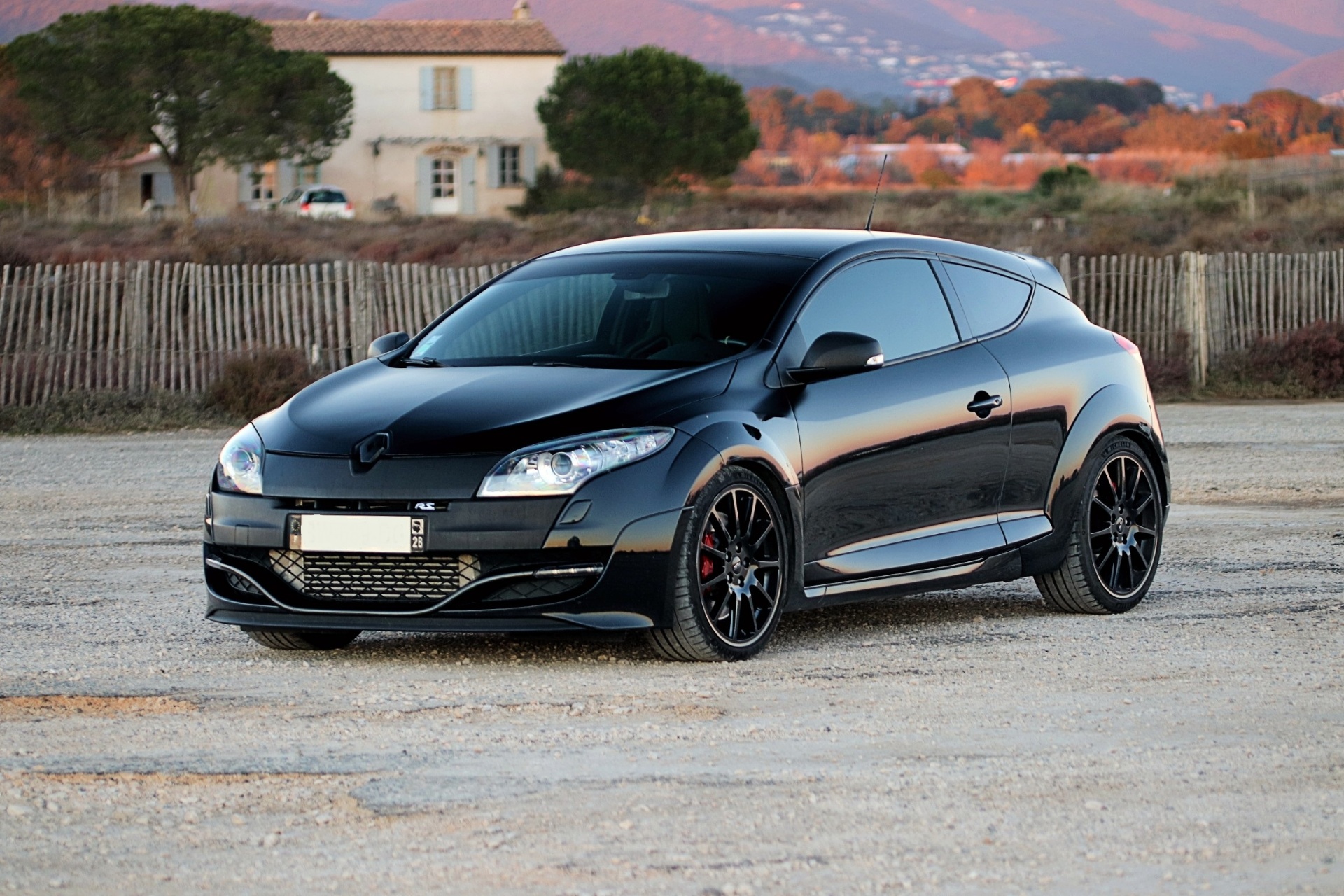 Renault Mégane 3 RS noire de face avec mas provençal en arrière-plan