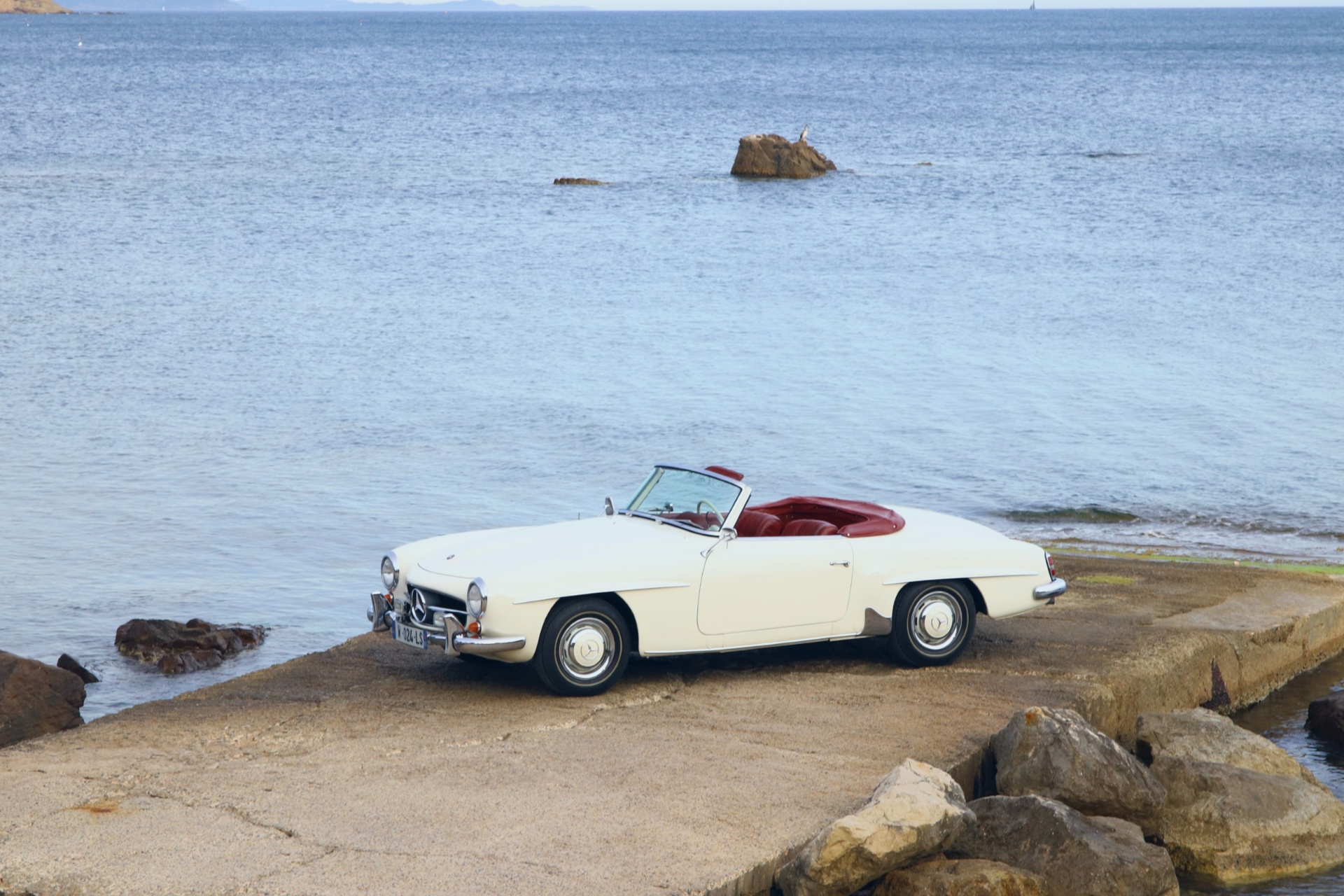 Mercedes-Benz 190 SL crème sur la jetée face à la Méditerranée