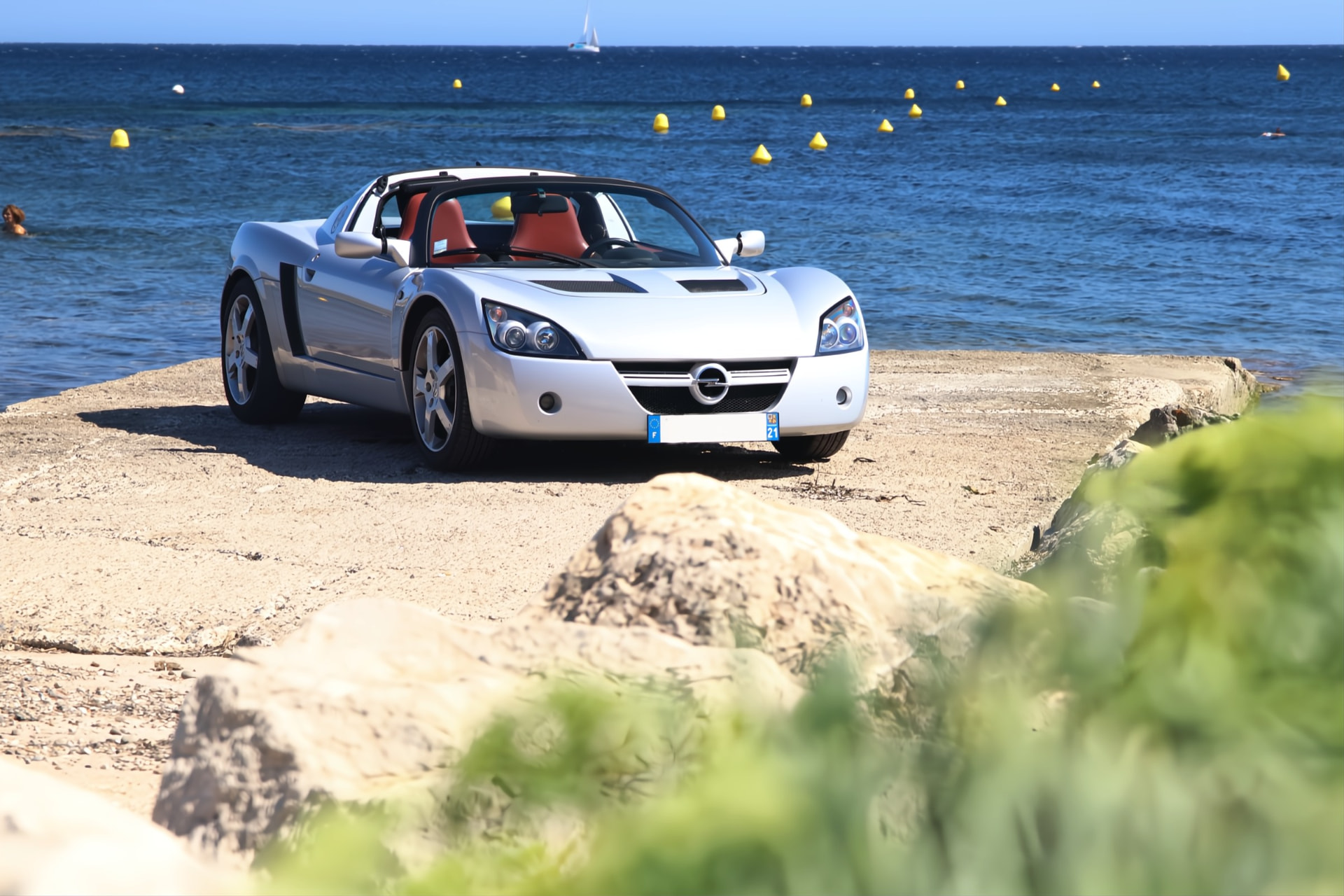 Opel Speedster argent de face sur une digue face à la mer
