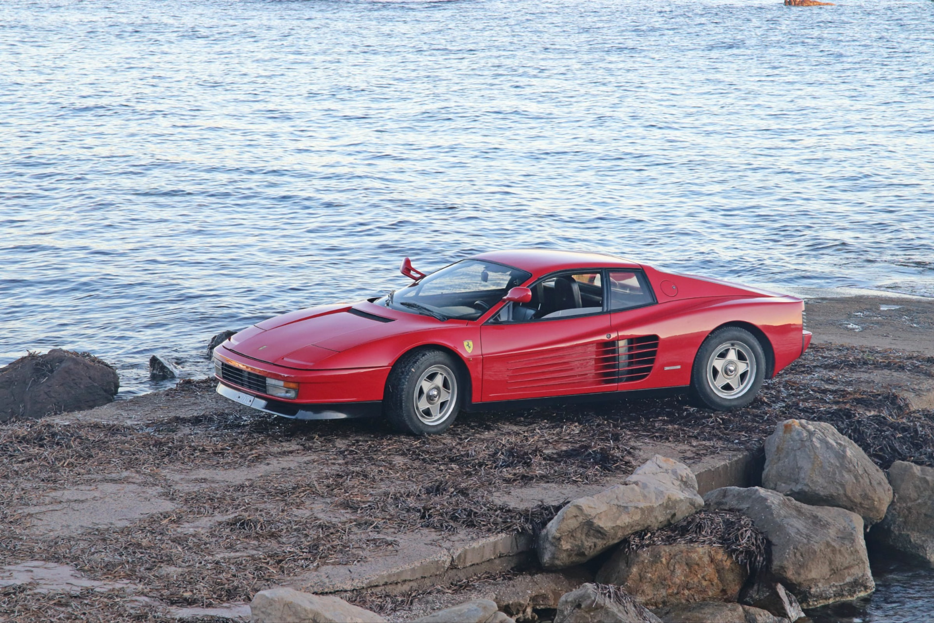 Ferrari Testarossa rouge monospecchio au bord de l'eau