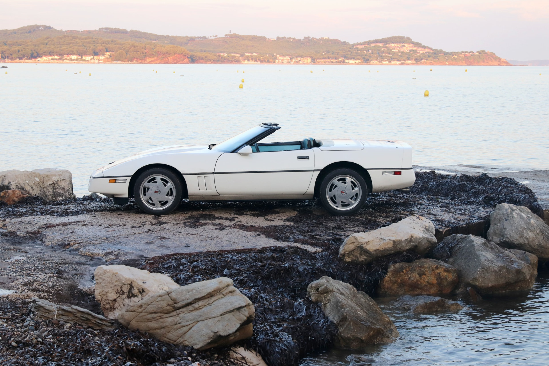 Corvette C4 cabriolet blanc de profil au bord de la mer