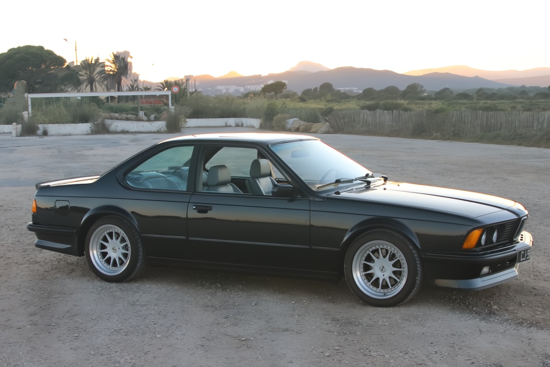 BMW M635 CSi noire de profil avec jantes BBS dans la lumière dorée
