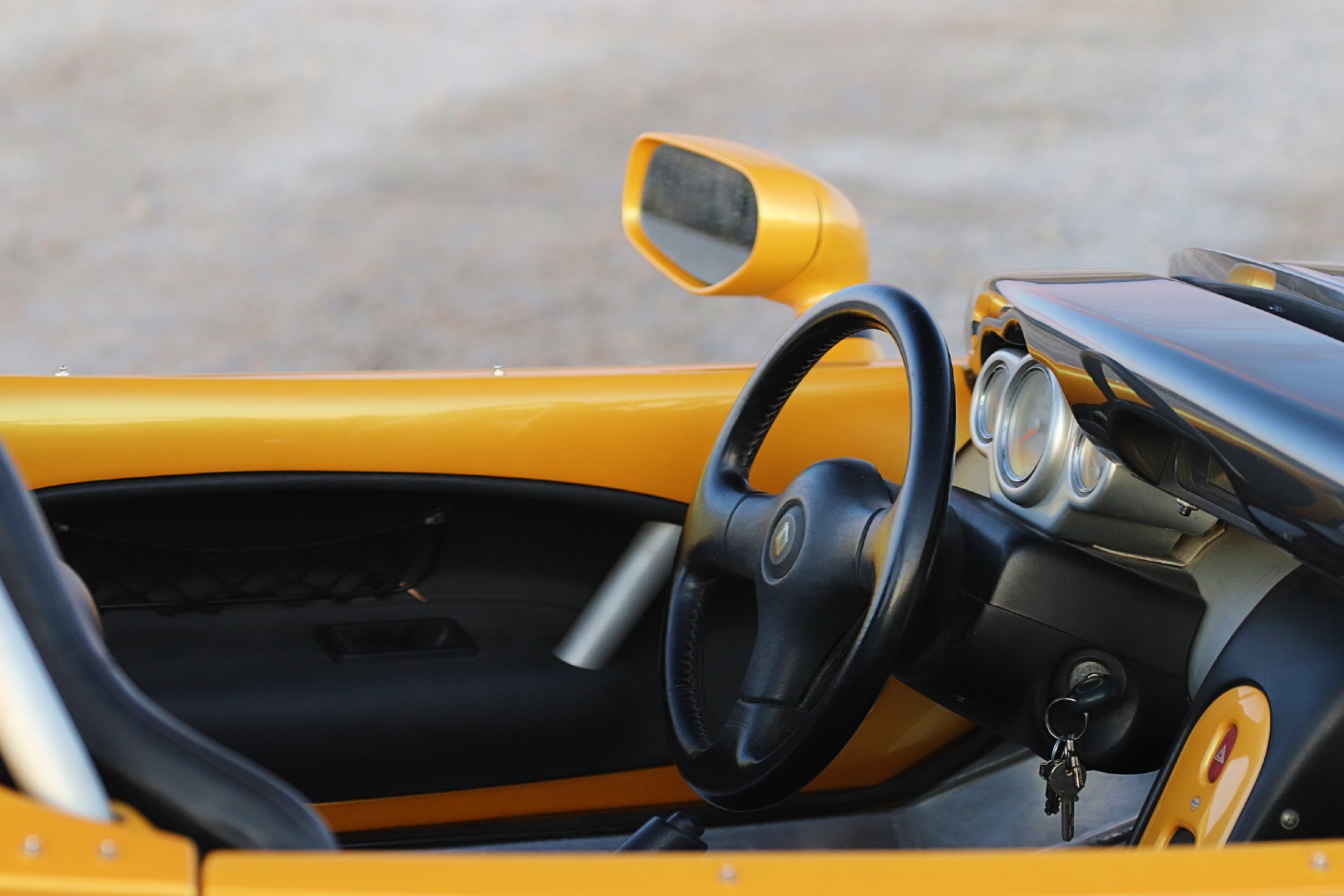 Intérieur Renault Spider, volant Renault, rétroviseur jaune et trois compteurs ronds