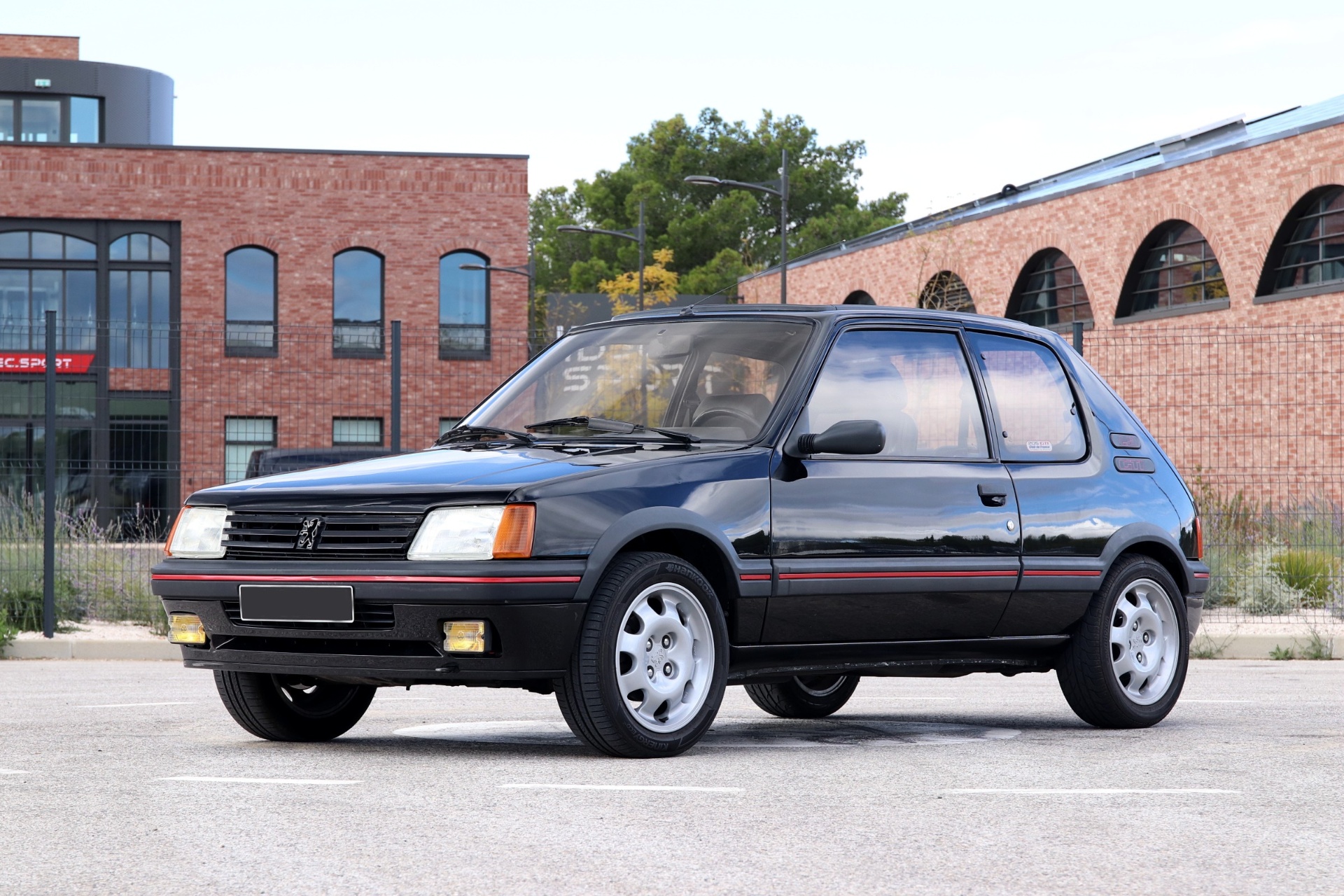 Peugeot 205 GTI 1.9 noire 130 ch dans un parking