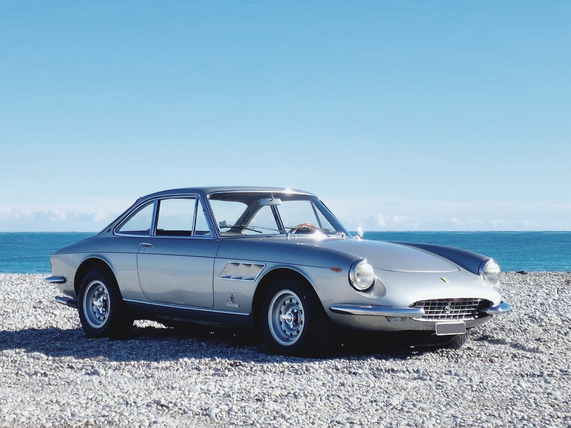 Ferrari 330 GTC argentée de 1967 garée face à la mer