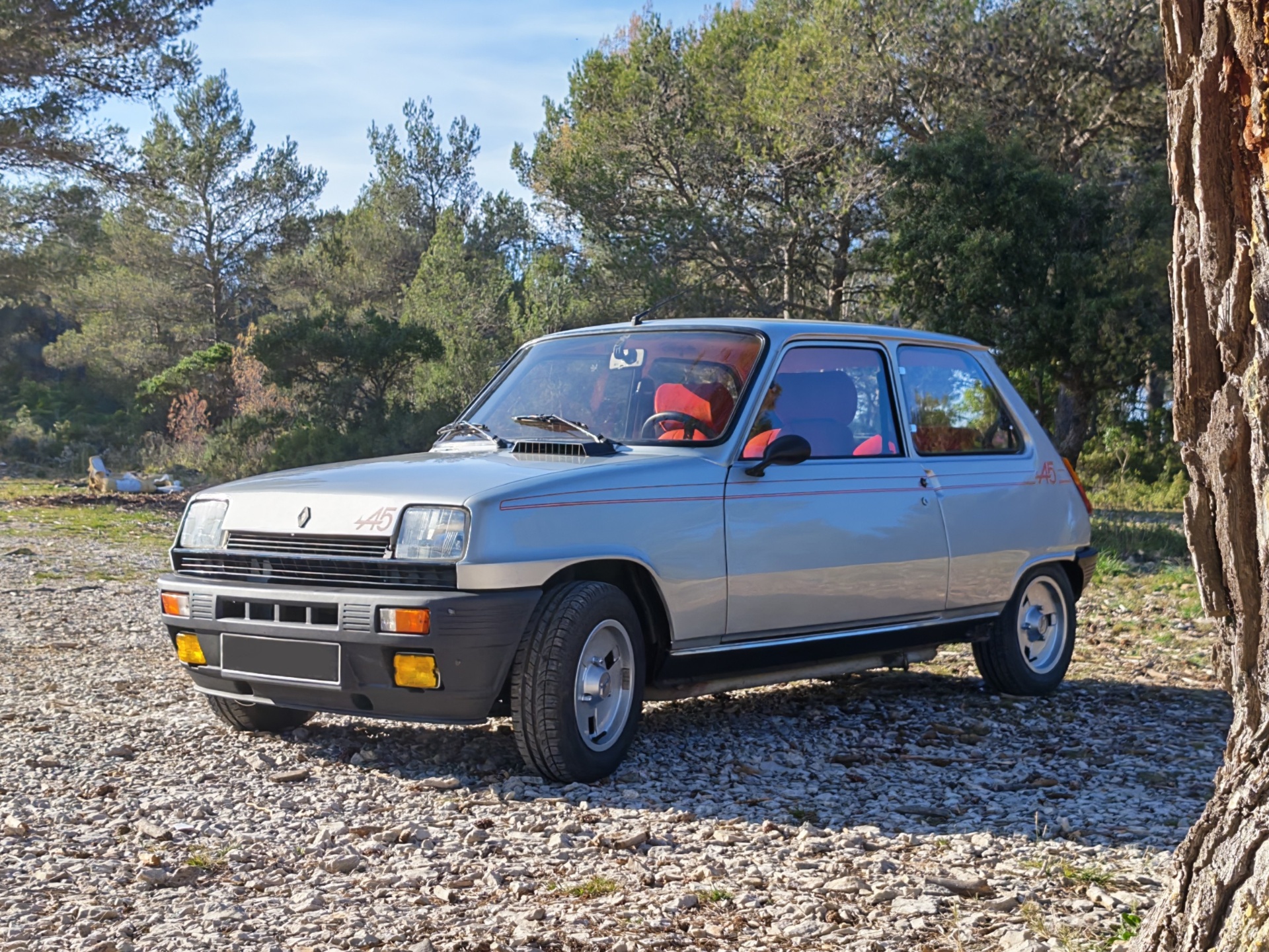 Renault 5 Alpine vue trois quarts avant avec sellerie rouge visible