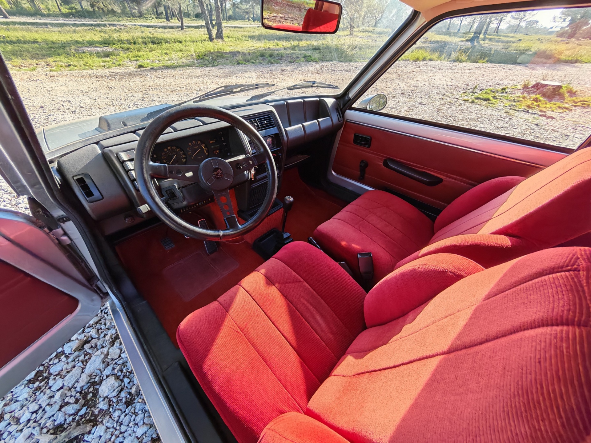 Poste de conduite rouge de Renault 5 Alpine vu côté passager