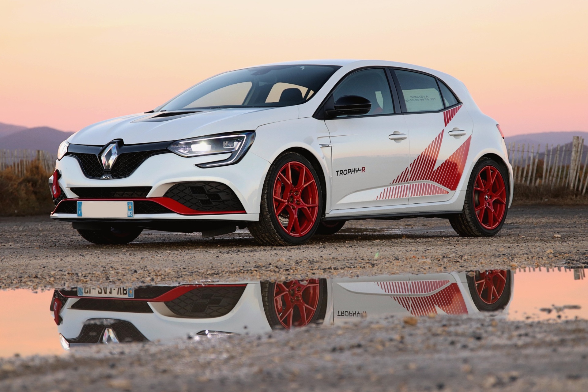 Mégane RS Trophy-R blanche avec jantes rouges au coucher du soleil