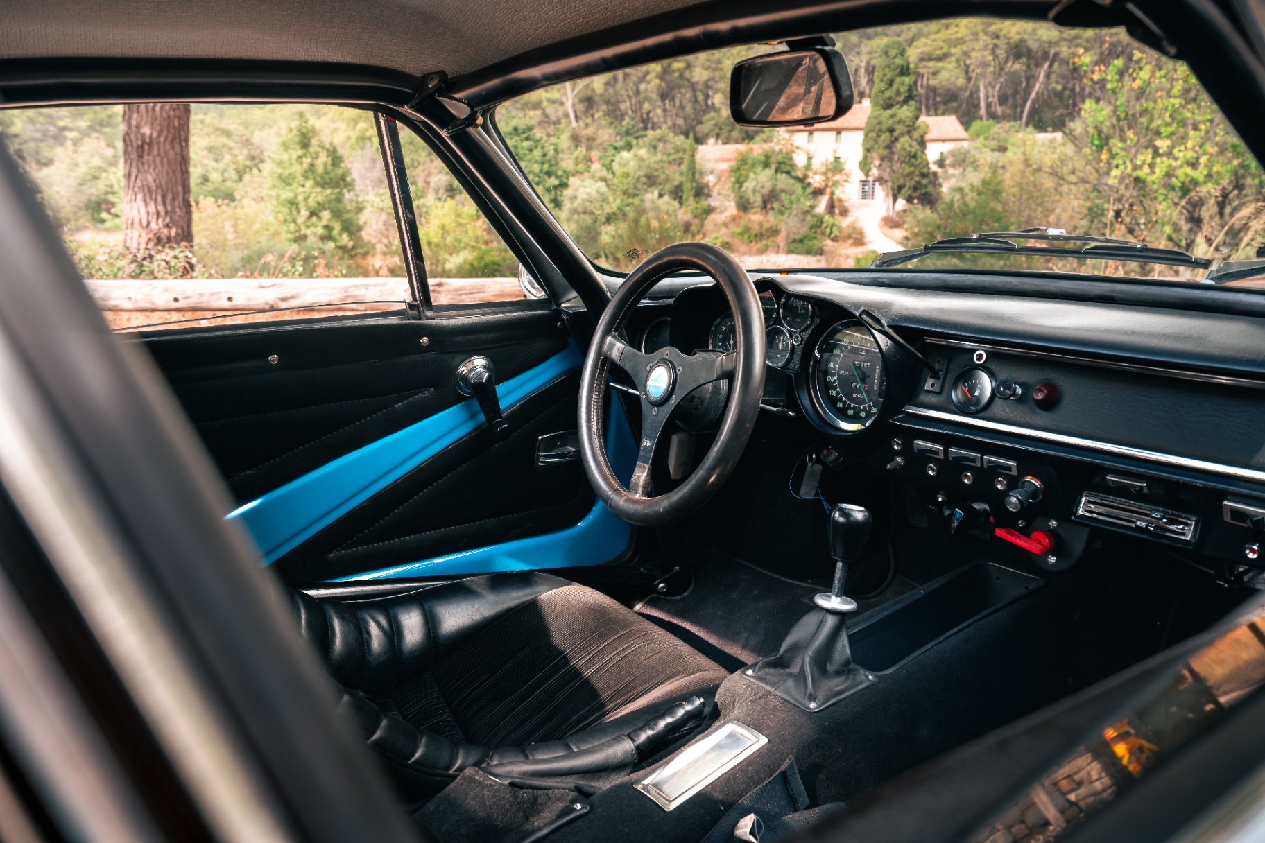 Habitacle de l'Alpine A110 1800 VB Bis avec arceau bleu et volant Momo