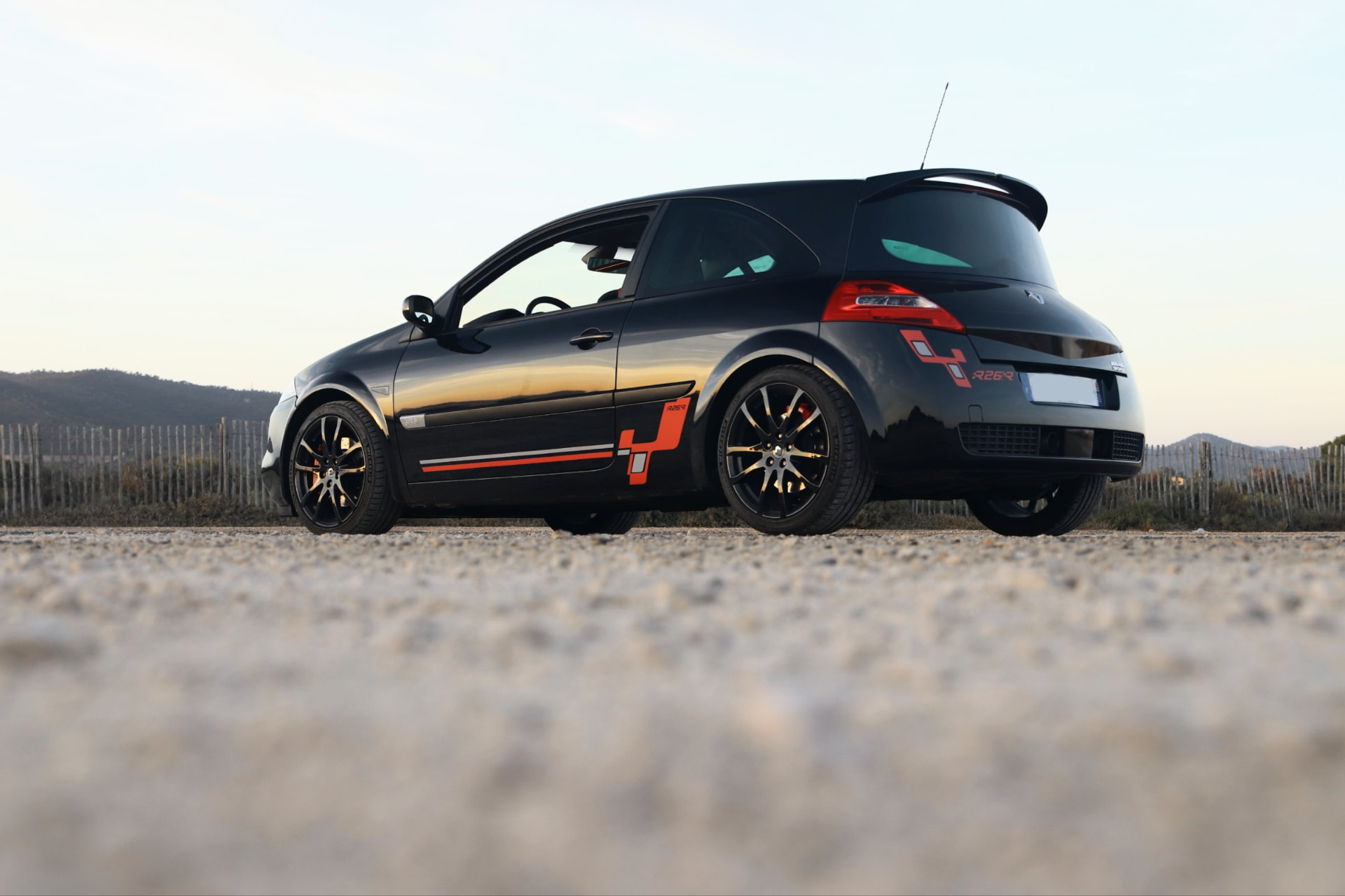 Mégane R26.R noire vue de l’arrière sur une route