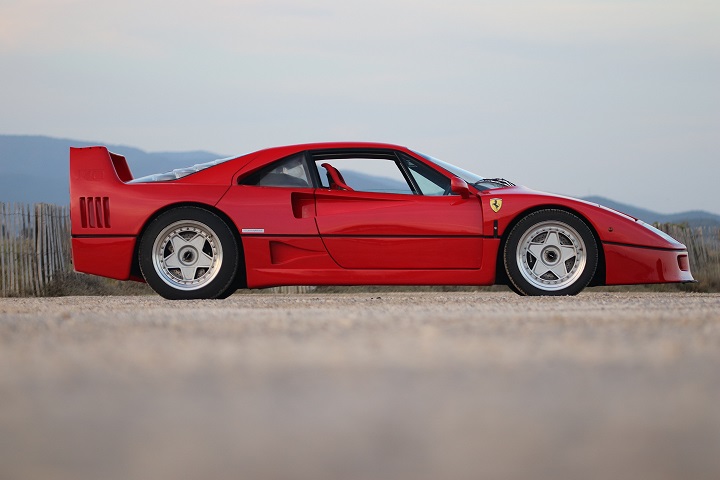 Ferrari F40 rouge de profil sur un chemin près de la mer