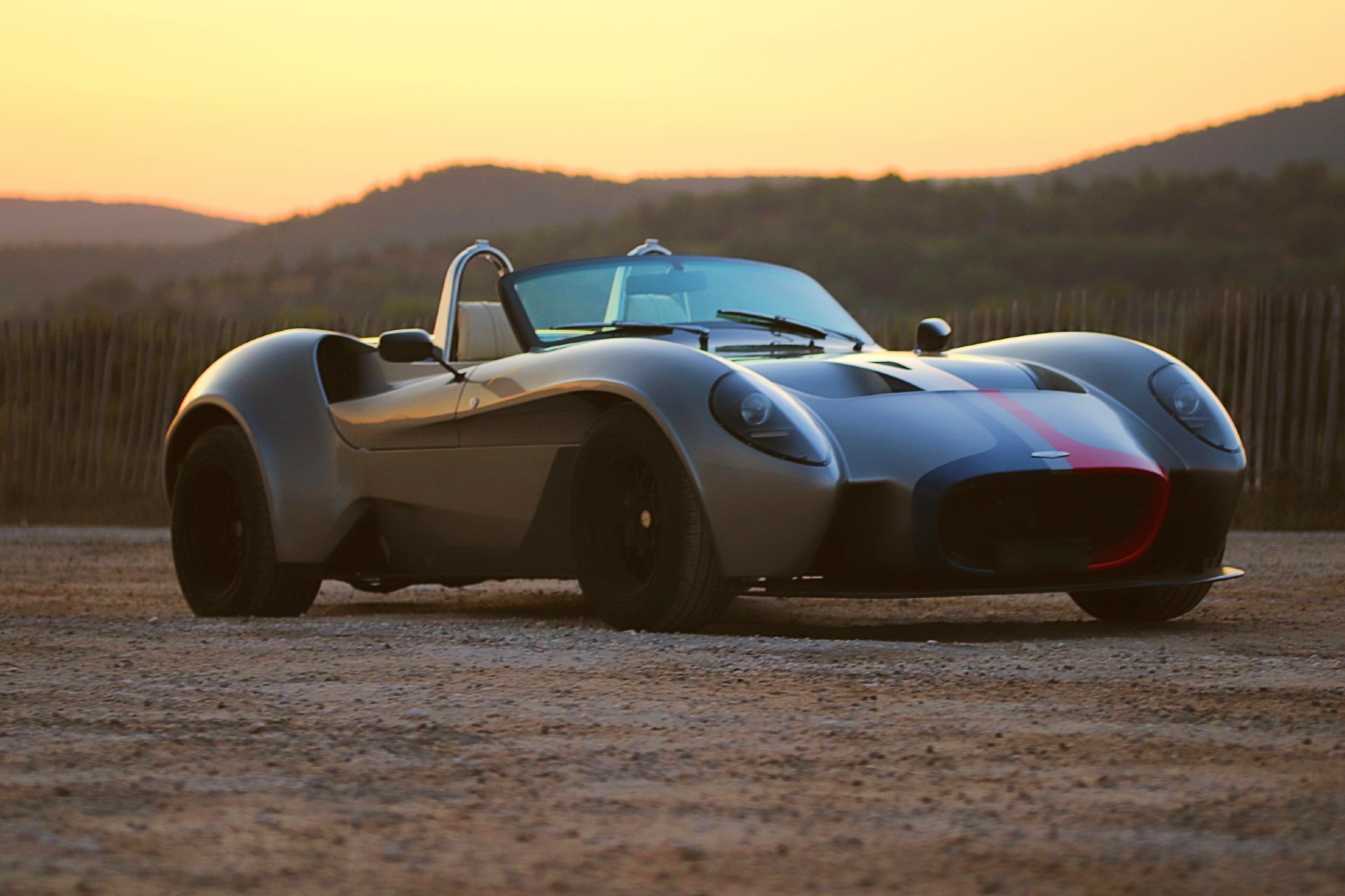 Jannarelly Design-1 grise à bandes bleu-blanc-rouge, vue de face au coucher de soleil.