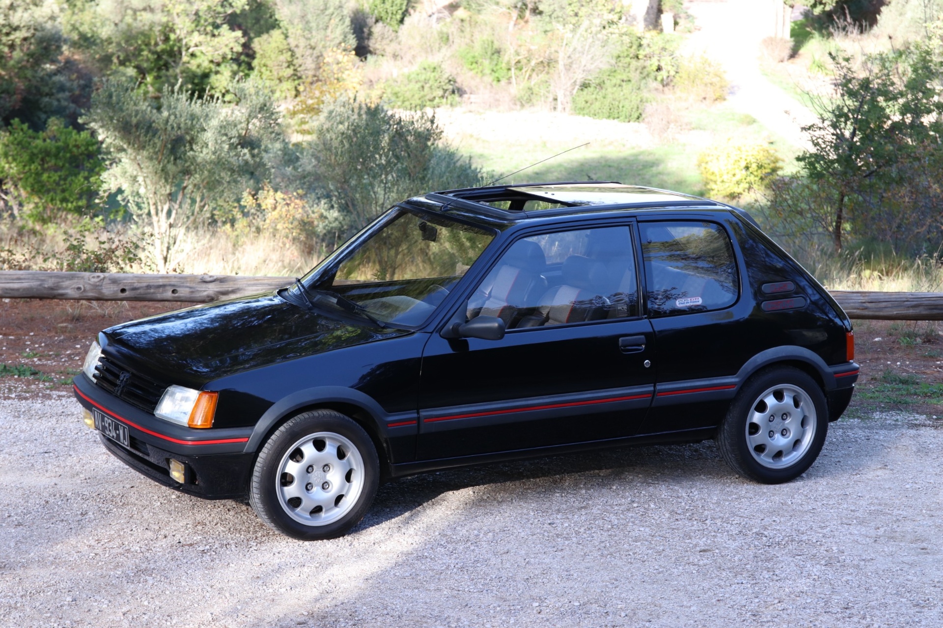 Peugeot 205 GTI 1.9 noire de trois quarts avant avec toit ouvrant