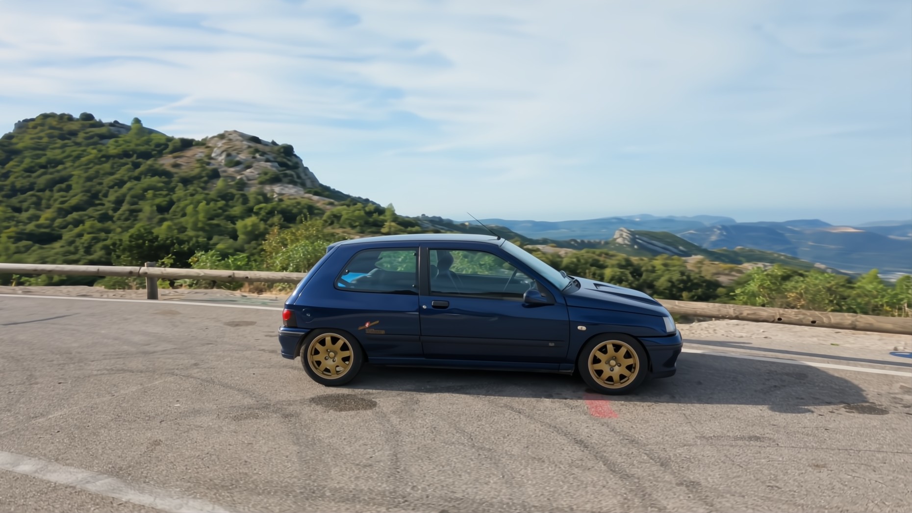 Renault Clio Williams de profil sur une route de montagne