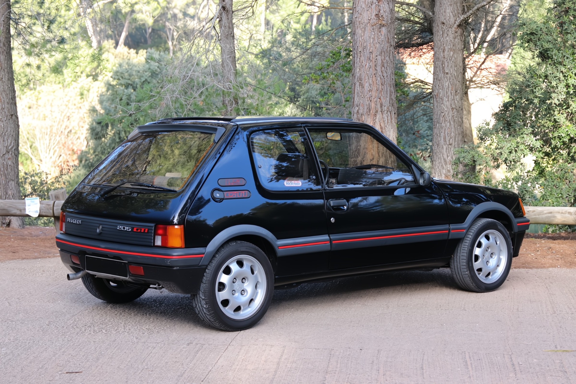 Peugeot 205 GTI 1.9 noire de trois quarts arrière en sous-bois