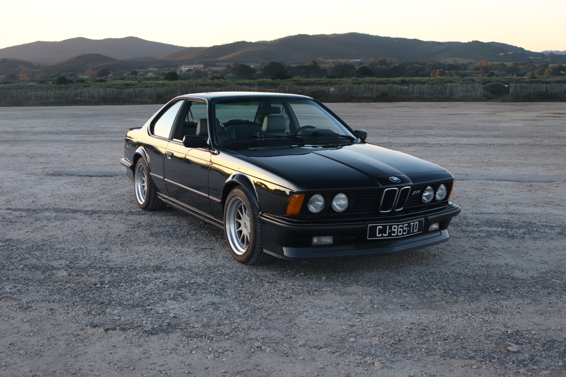 BMW M635 CSi noire de trois-quarts avant, profil bas et jantes argent