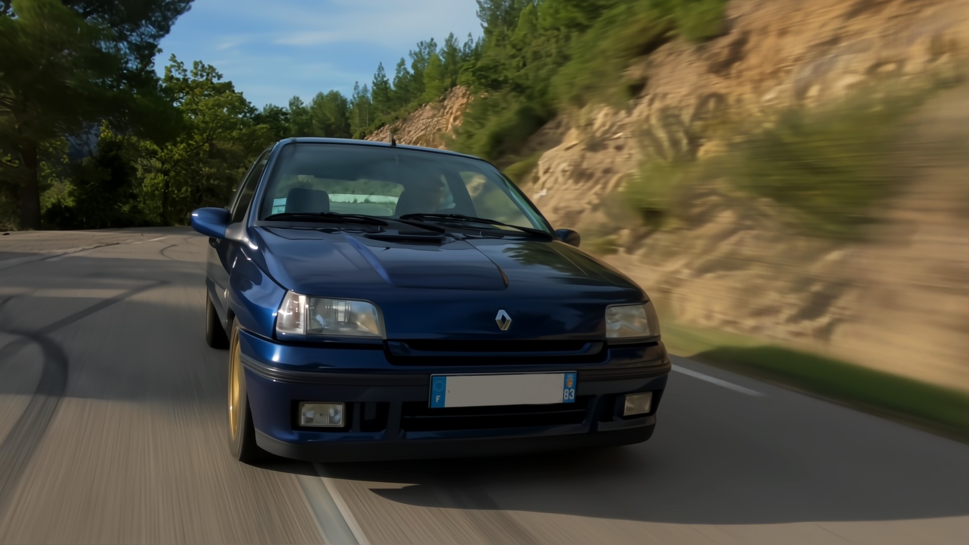 Renault Clio Williams bleue de face sur une route de campagne