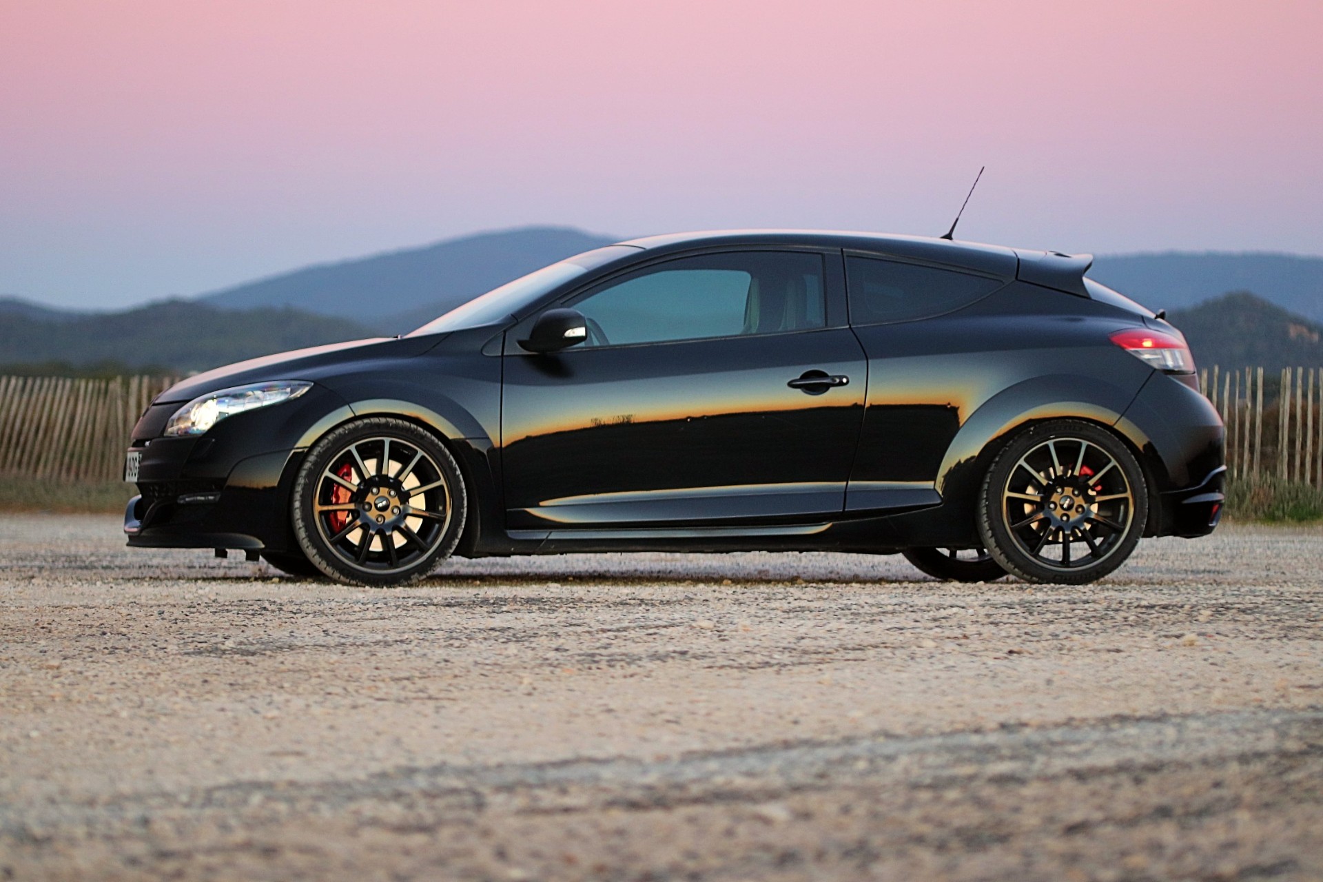 Renault Mégane 3 RS noire de profil au coucher du soleil