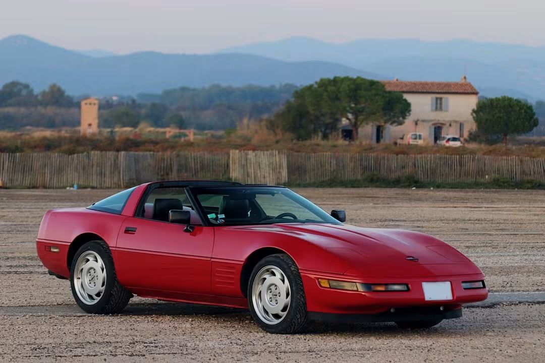Corvette C4 LT1 rouge de trois quarts avant au coucher du soleil