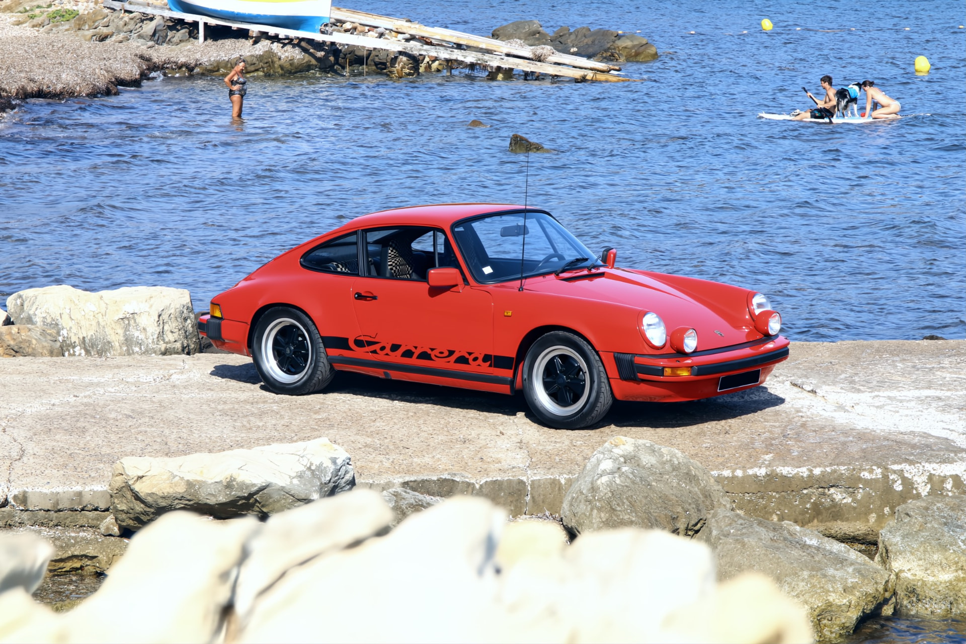 Porsche 911 SC rouge sur une cale au bord de la mer