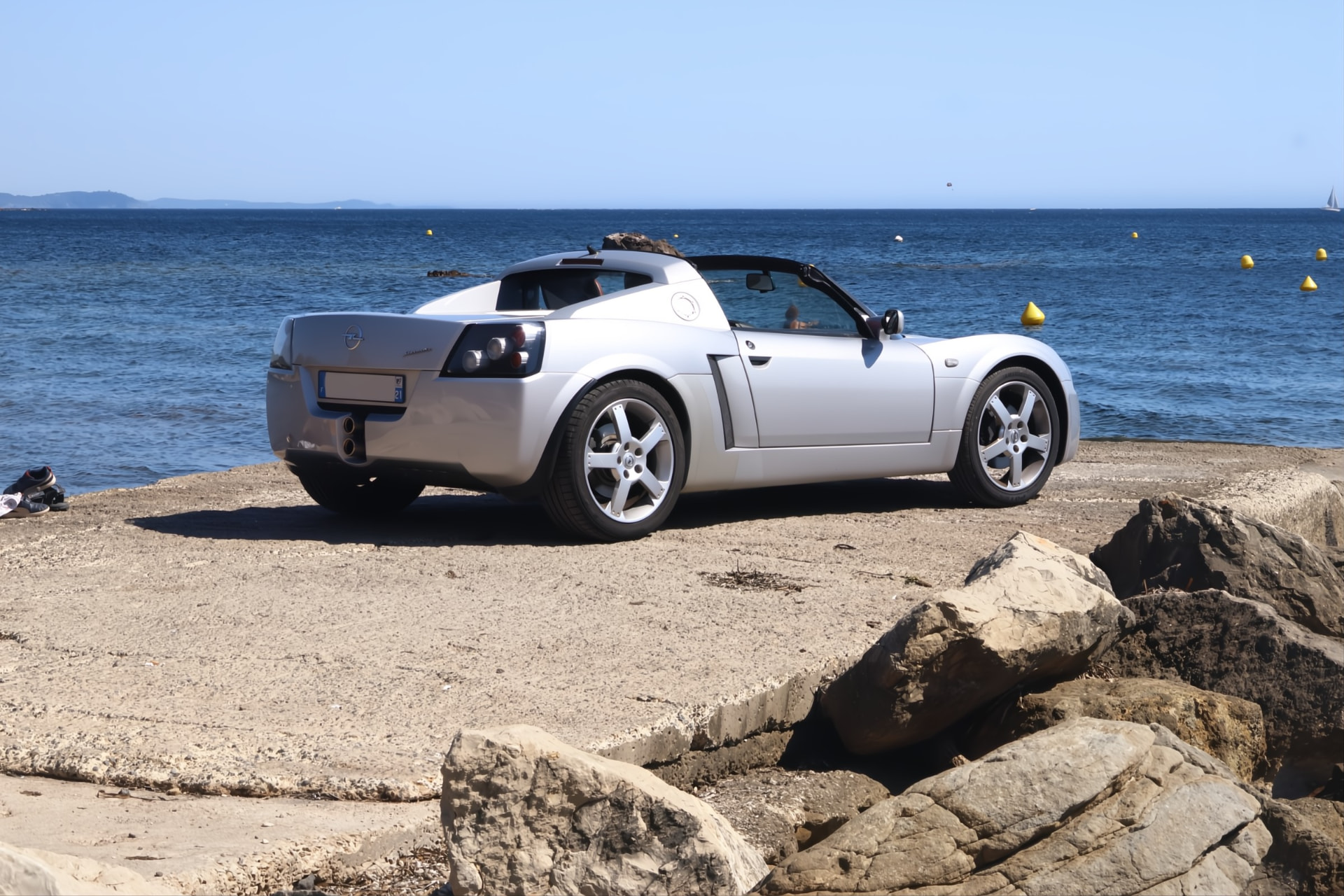 Opel Speedster argent vu de trois-quarts arrière au bord de l'eau