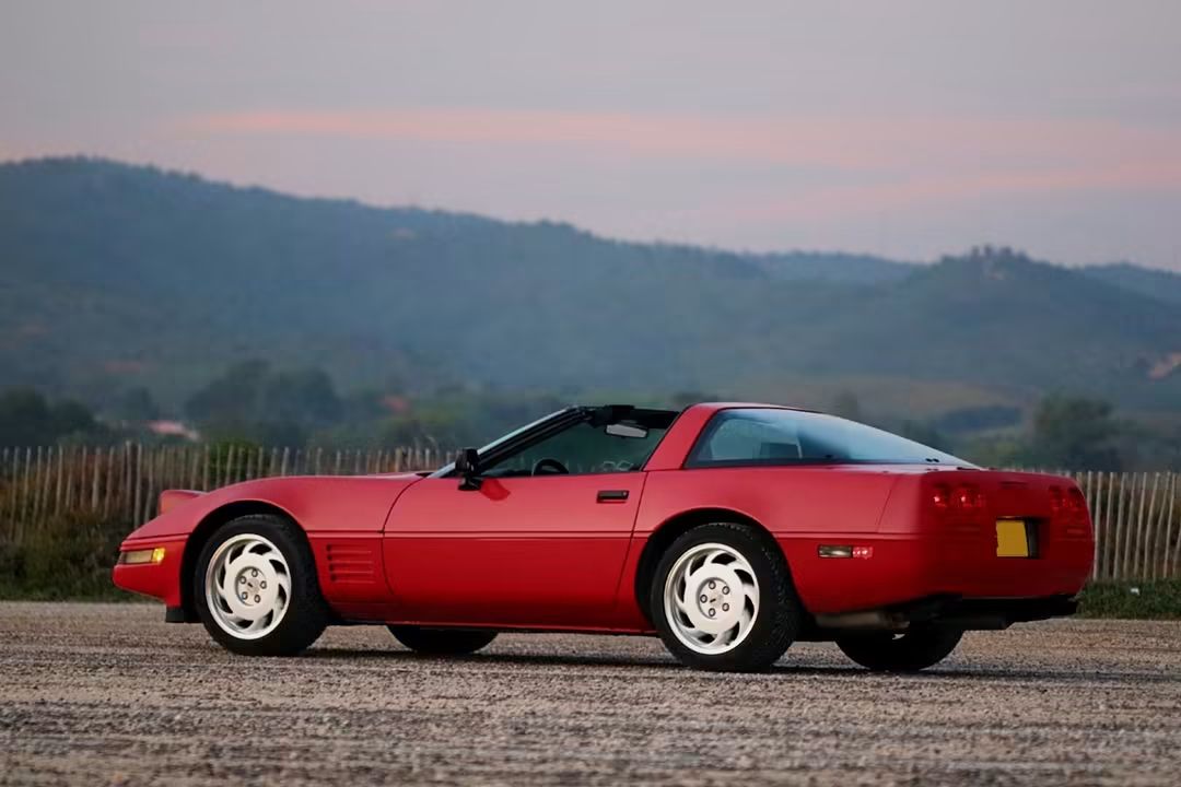 Corvette C4 LT1 rouge de trois quarts arrière face aux collines
